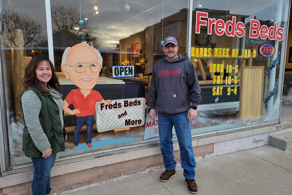 Image of two employees of Fred's Beds in front of their Main Street store front.