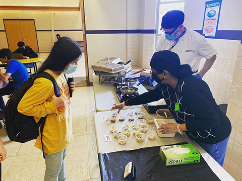 Student sampling Indian food at Madison East High School.