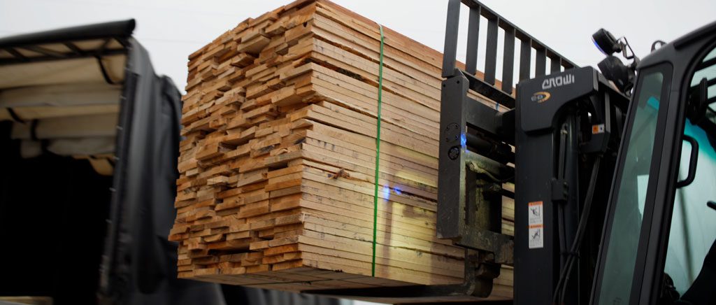 Forklift loading lumber into truck.
