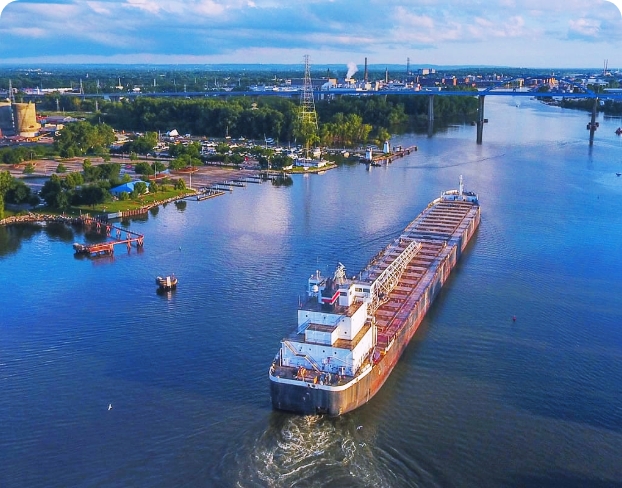 A massive cargo ship sailing along a river.