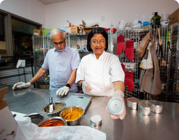 Two individuals cooking in a kitchen.