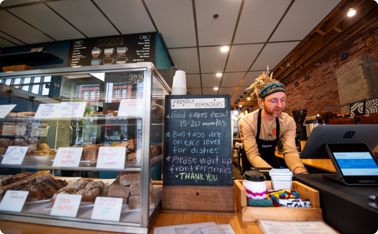 A man working behind the counter at a coffee shop.