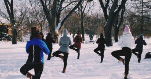 People doing yoga outside in snow