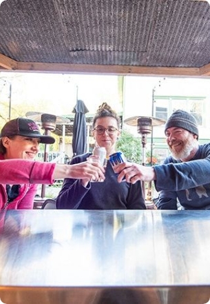 Three friends cheers at an outdoor patio.