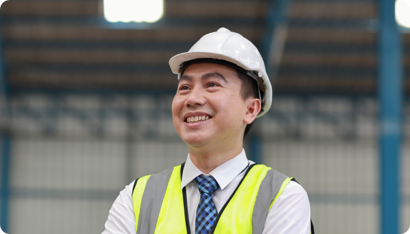 Image of a business man with a yellow jacket and a white hard hat