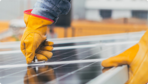 Close-up image of a worker's hands assembling a solar panel.