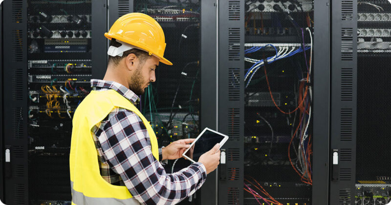 Image of data center worker in front of server racks.