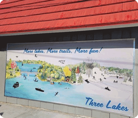 A mural painted on the side of a building displaying activities in Three Lakes, WI