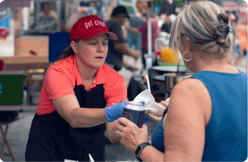 Women make a transaction at the Night Market in Fond du Lac