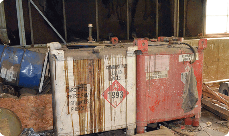 Large containers of contaminated chemicals left behind at a commercial property