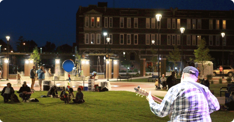 Person playing guitar at an outdoor venue.