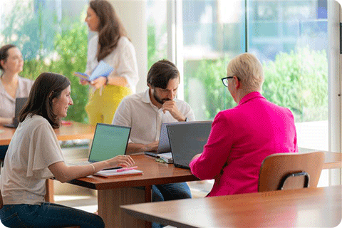 Image of people working on computers at a table.