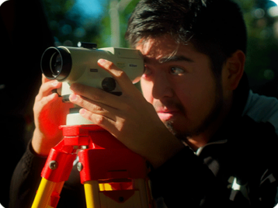 Student at UW Milwaukee using surveying equipment.