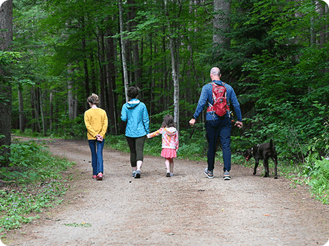 A family hiking with their dog on the Three Eagle Trail in Oneida County.