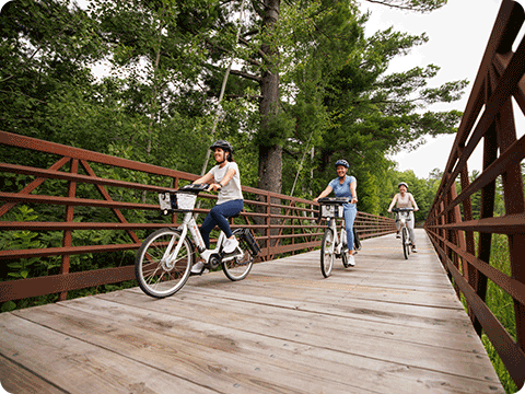 Three women riding bikes on the Heart of Vilas Trail System.