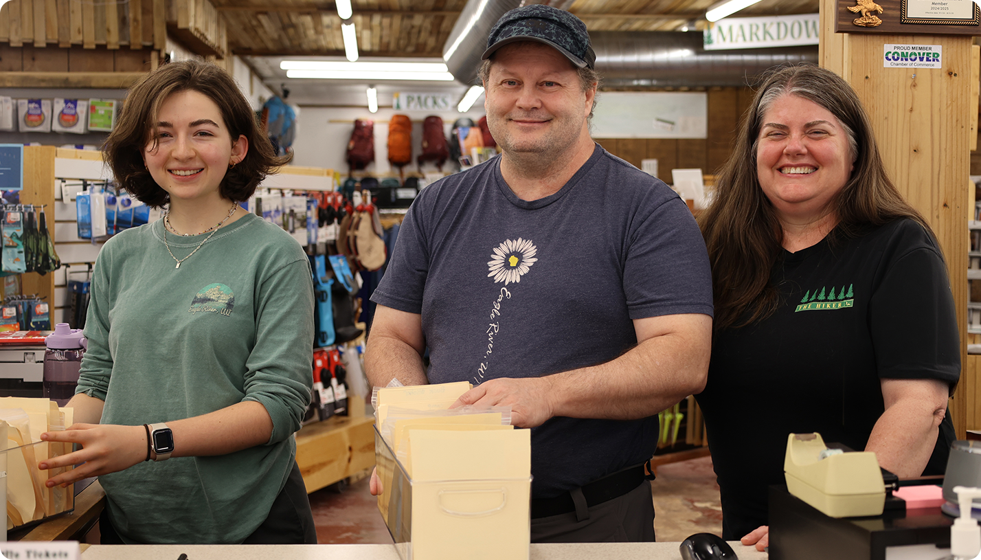 SBA-26-web-1428×815 Three people working at the counter of a retail store.