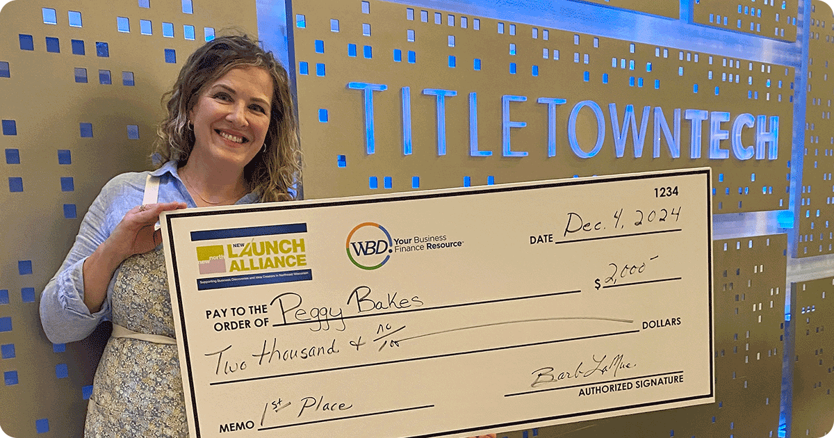 Peggy Sonnenburg, owner of Peggy Bakes holding a large check.