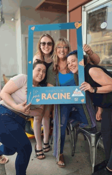 Four women posing with Love Racine photo frame.
