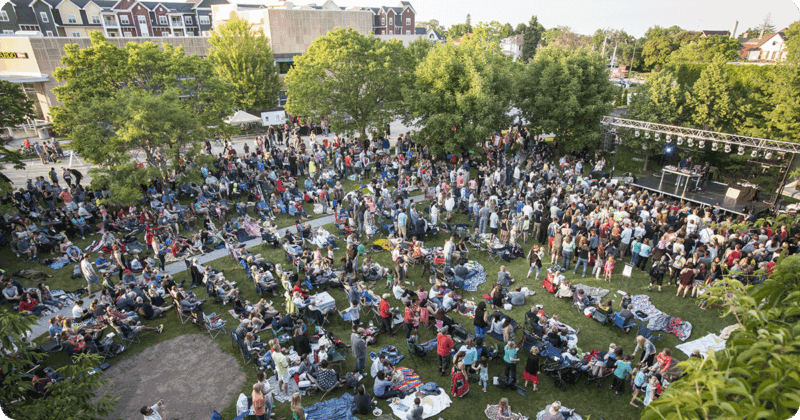 Ariel image of people sitting on the lawn at a Sheboygan outdoor concert.