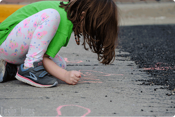 Images of a child drawing on a sidewalk with chalk.
