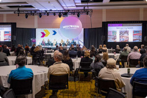 Summit panel with audience Wisconsin Economic Summit audience listening to panel discussion.