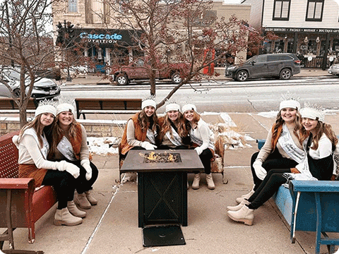 Teenage girls sitting around a fire pit in downtown Osceola.