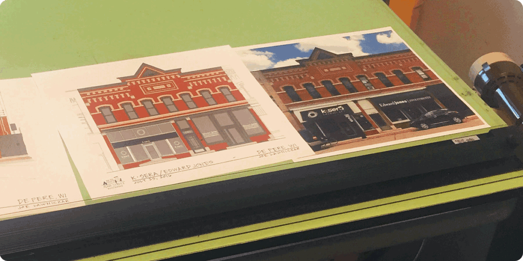 Drafting table with artwork and photos.