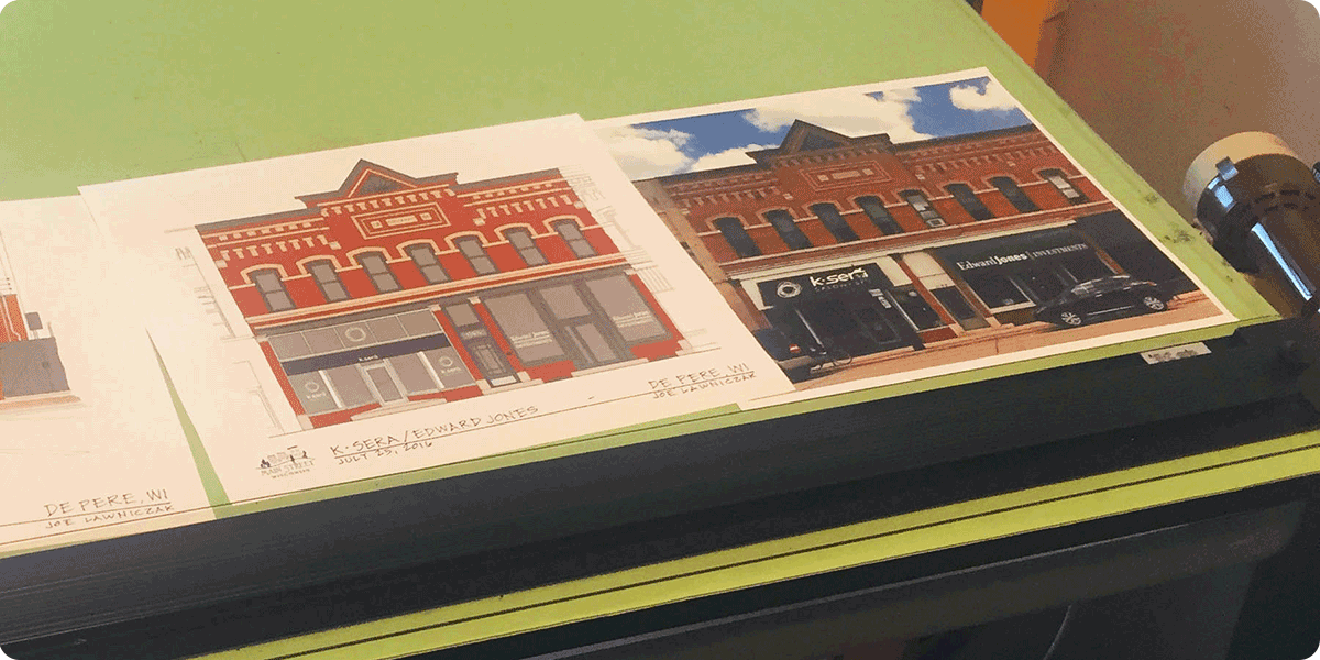 Drafting table with artwork and photos.
