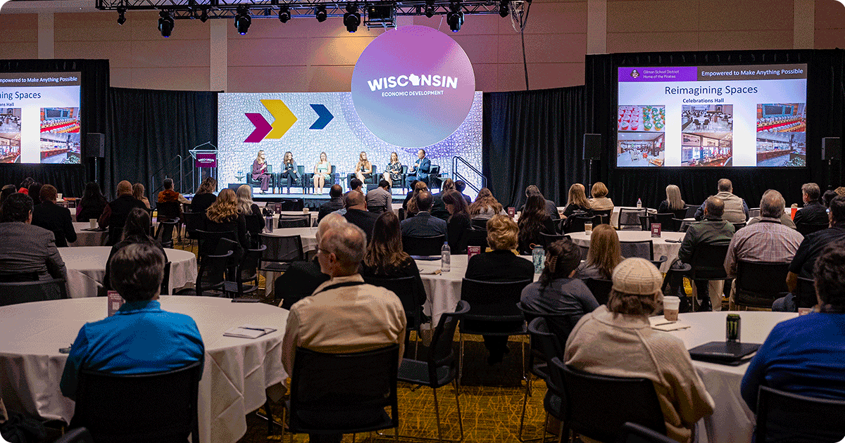 Panel discussion with audience members sitting at round tables at the Wisconsin Economic Summit.