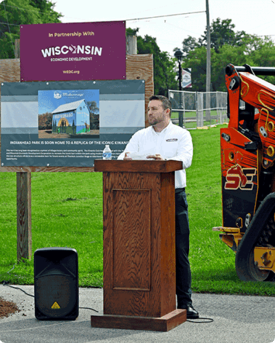 Natanael Martinez, a regional economic development director from WEDC, address the crownd gathered at the Mukwanago Kiwanis concession barn shovel ceremony.