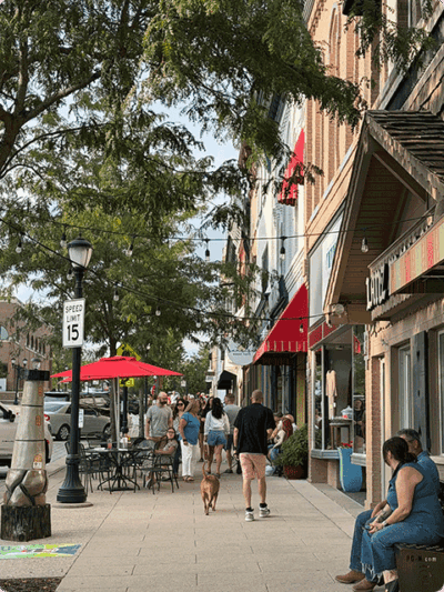 People walking down the sidewalk in downtown Monroe.