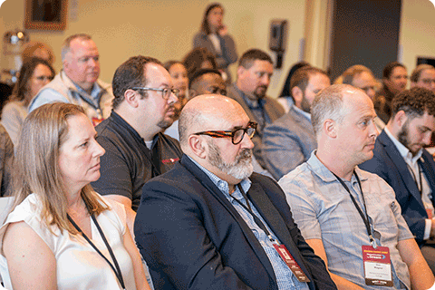 Audience members listening to panel discussion of leaders from higher education institutions.